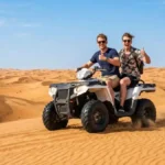 Two riders on an ATV quad bike on Abu Dhabi desert dunes