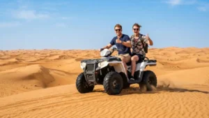 Two riders on an ATV quad bike on Abu Dhabi desert dunes
