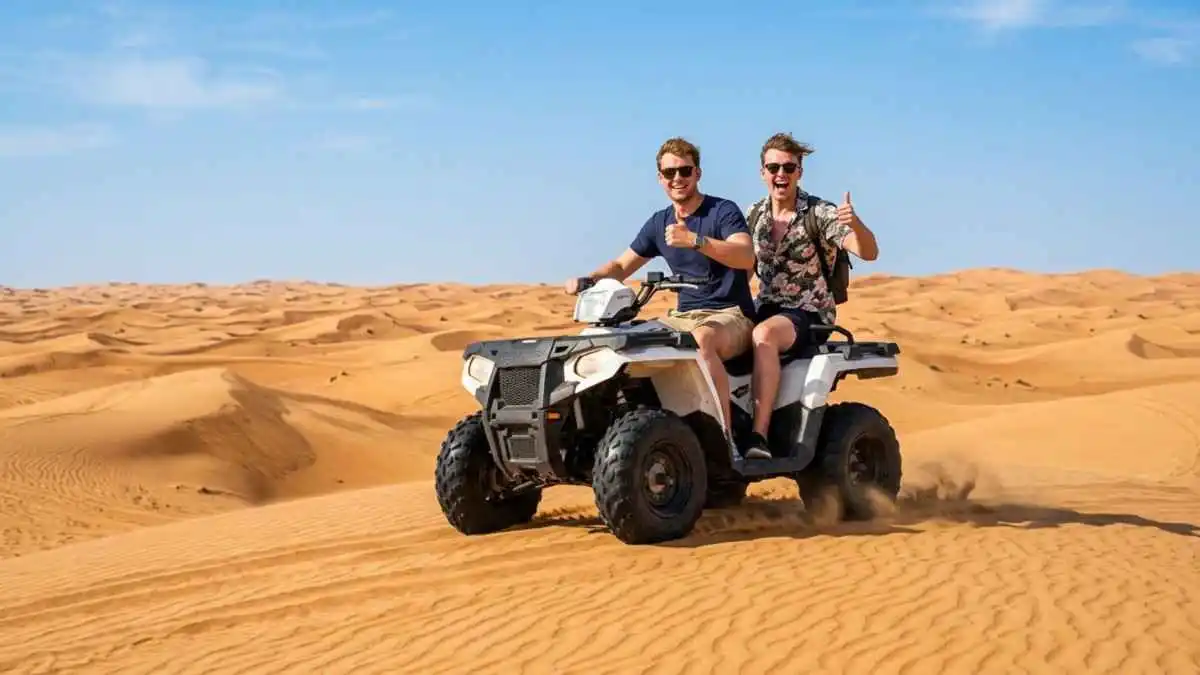 Two riders on an ATV quad bike on Abu Dhabi desert dunes