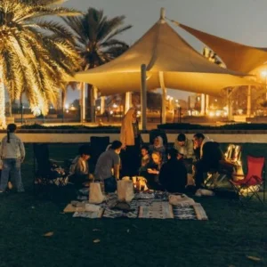 Guests enjoying a traditional BBQ dinner at a desert camp during an Evening Desert Safari Abu Dhabi.