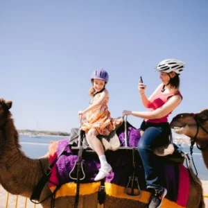 Family enjoying a camel ride during an Evening Desert Safari Abu Dhabi experience.