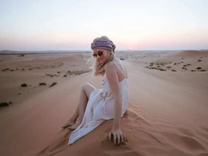 Guest enjoying the sunset during an Evening Desert Safari Abu Dhabi on the golden sand dunes.