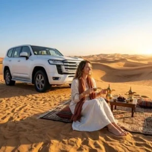 Female tourist relaxing beside a 4x4 vehicle during a luxury Morning Desert Safari Abu Dhabi experience.