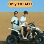 Two Tourists Enjoying ATV Quad Bike Ride on Sand Dunes in Desert Safari Abu Dhabi