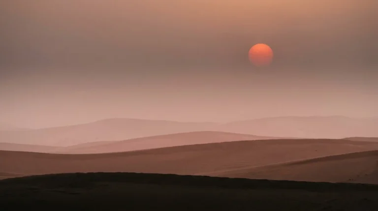Thick dust haze turning the August sun deep red over the Abu Dhabi dunes