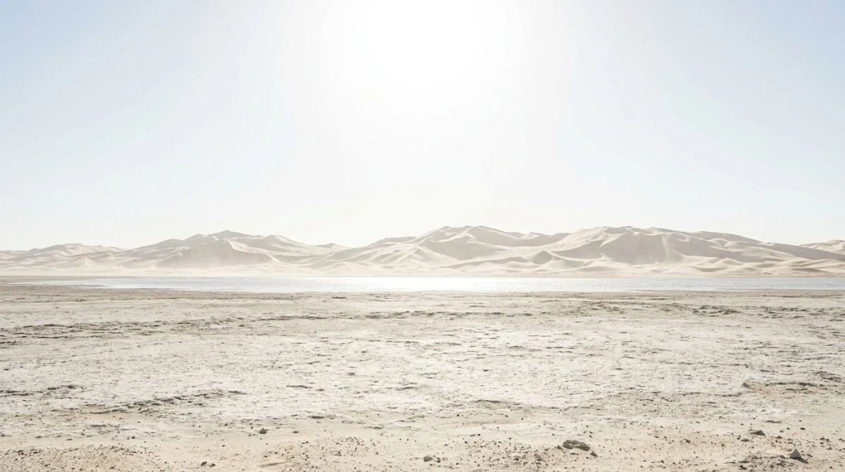 Blinding white midday light and a mirage over the Abu Dhabi desert in June