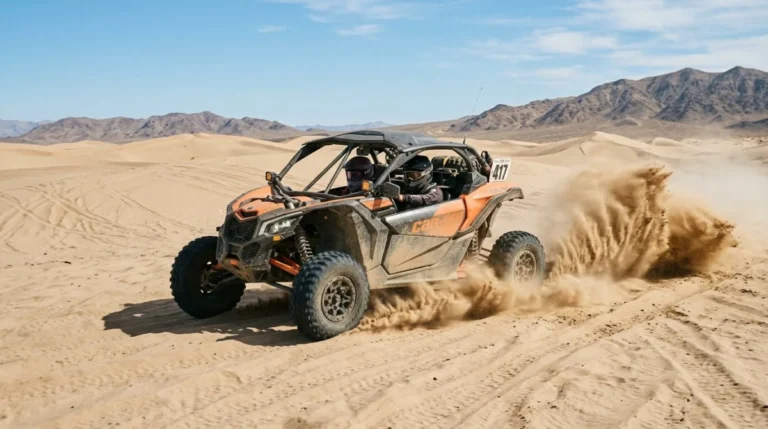A two-seater dune buggy crossing soft sand on a desert safari near Abu Dhabi