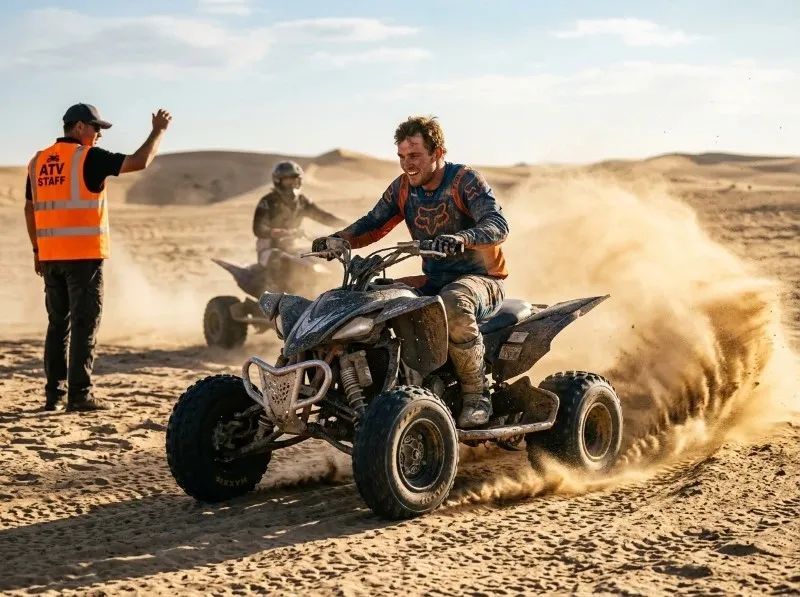 Rider on a quad bike ATV kicking up sand across the dunes on a quad bike tour in Abu Dhabi