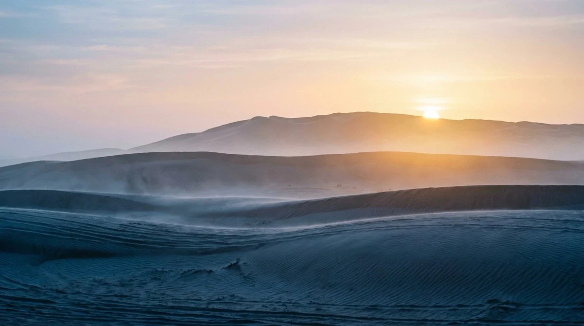 Low mist over the dunes as the sun comes up on a sunrise desert safari